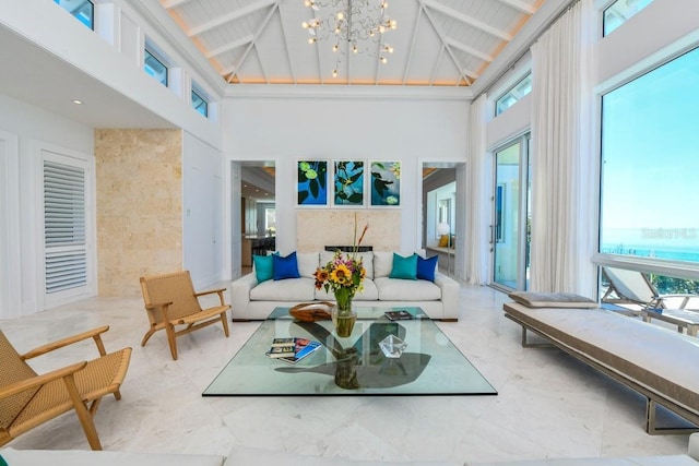 interior space featuring lofted ceiling with beams, a notable chandelier, and plenty of natural light