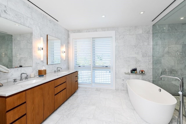 bathroom featuring tile walls, a tub to relax in, and vanity