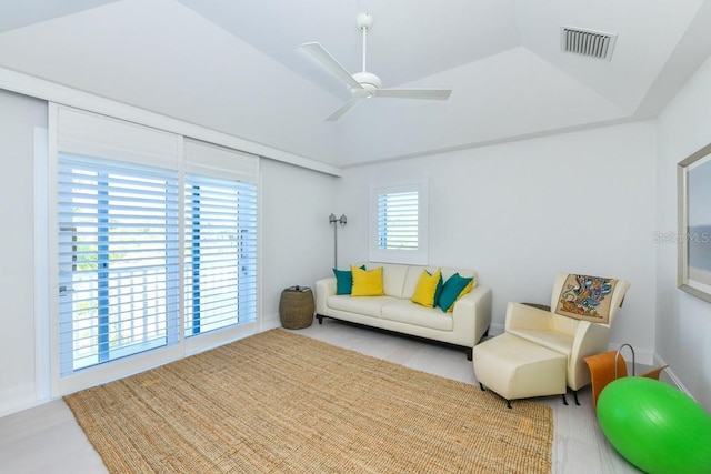 living room with ceiling fan and a tray ceiling