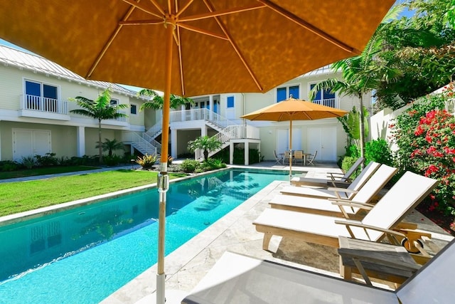 view of swimming pool featuring a patio area and a lawn