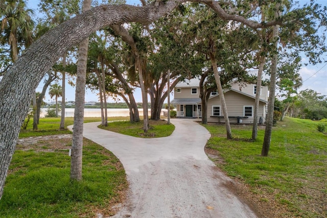 view of front of house with a front yard and a water view