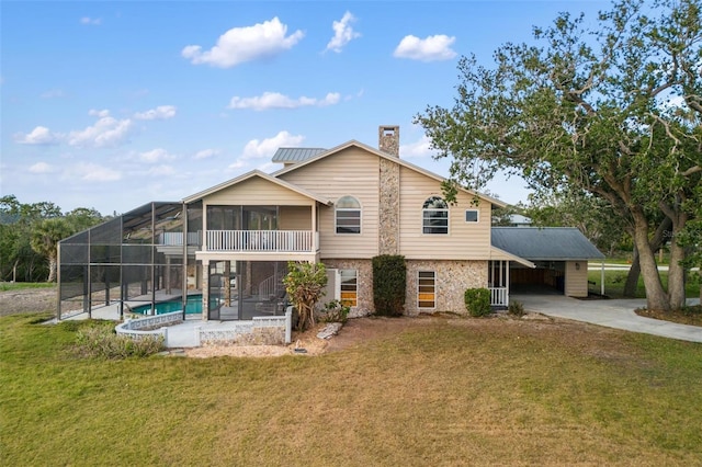 back of property with glass enclosure, a sunroom, a yard, a carport, and a fenced in pool