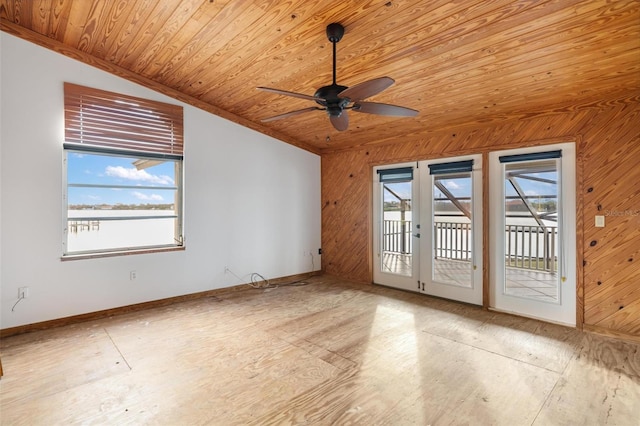 spare room featuring french doors, ceiling fan, wooden walls, wooden ceiling, and lofted ceiling