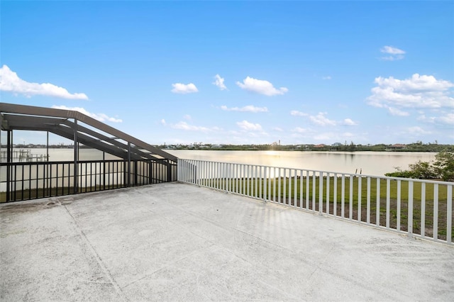 view of patio / terrace featuring glass enclosure and a water view