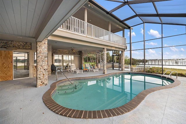 view of swimming pool with a patio, glass enclosure, and ceiling fan