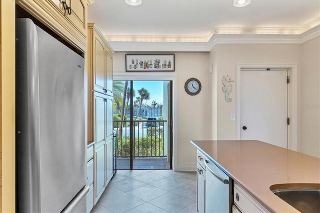 kitchen with light tile patterned floors, stainless steel appliances, and ornamental molding