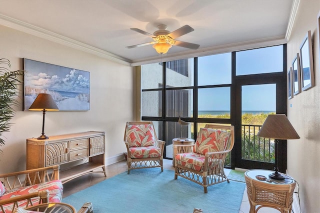 sitting room with tile patterned floors, a wealth of natural light, ornamental molding, and ceiling fan