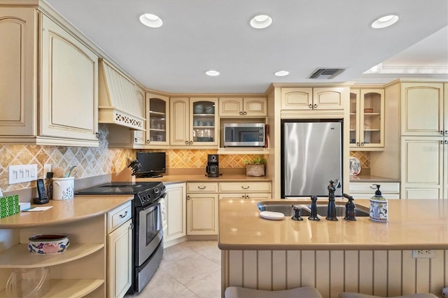 kitchen featuring premium range hood, sink, decorative backsplash, appliances with stainless steel finishes, and light tile patterned flooring