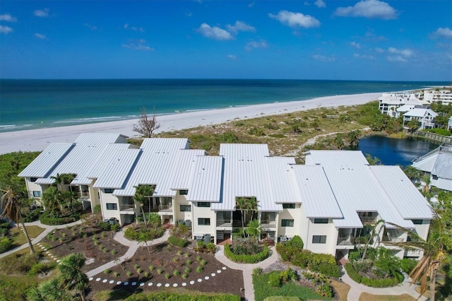 birds eye view of property with a water view and a beach view