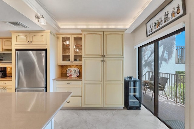 kitchen featuring cream cabinetry, stainless steel fridge, decorative backsplash, and light tile patterned floors