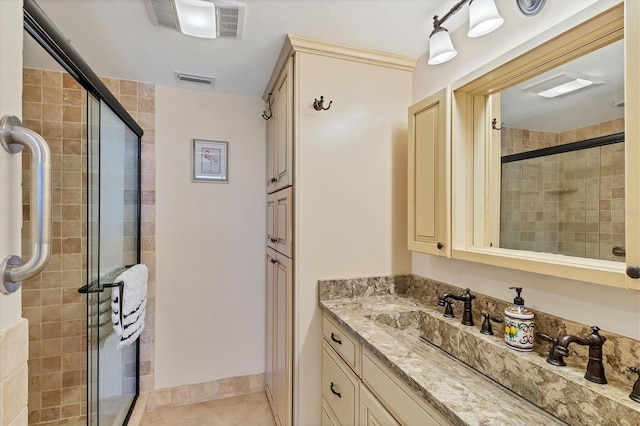 bathroom featuring tile patterned flooring, vanity, and a shower with shower door