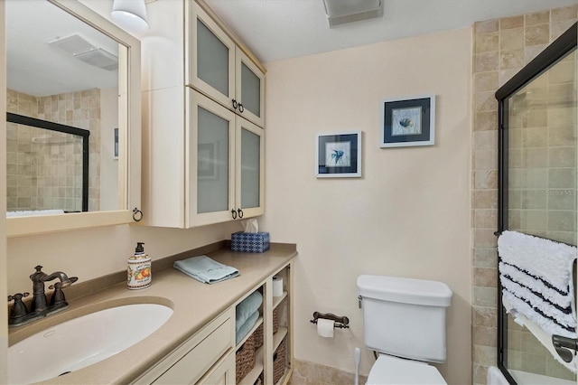 bathroom featuring a shower with door, vanity, and toilet