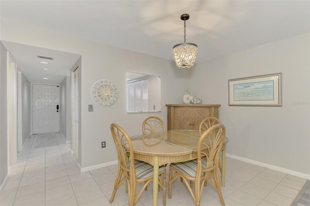 dining space featuring light tile patterned floors and a chandelier