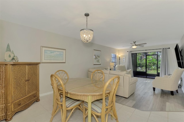 dining space with ceiling fan with notable chandelier