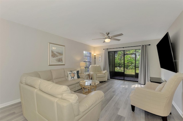 living room with light hardwood / wood-style flooring and ceiling fan