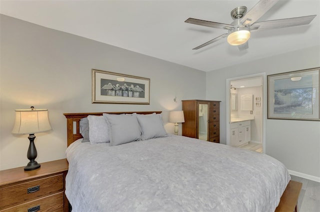 bedroom with ceiling fan, light hardwood / wood-style flooring, and connected bathroom