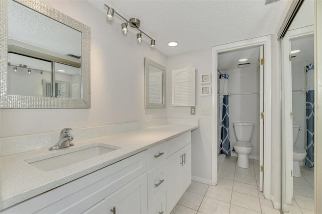 bathroom featuring tile patterned floors, a textured ceiling, vanity, and toilet