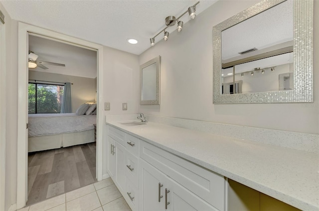 bathroom featuring tile patterned floors, ceiling fan, vanity, and a textured ceiling