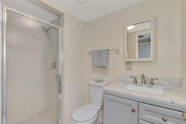 bathroom with a textured ceiling, vanity, toilet, and a shower with shower door