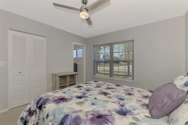 carpeted bedroom with ceiling fan and a closet