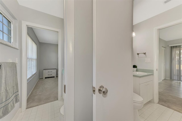 bathroom with tile patterned floors, vanity, toilet, and plenty of natural light