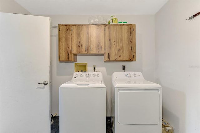 laundry room featuring washer and dryer and cabinets