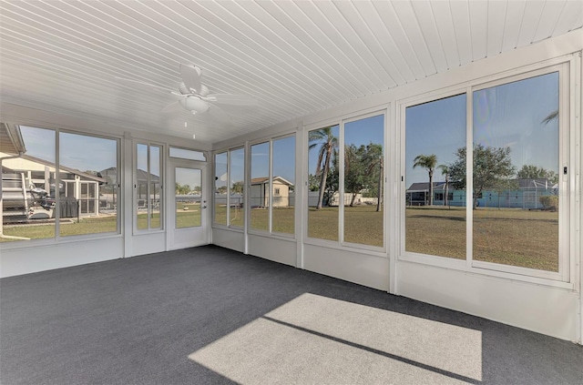 unfurnished sunroom featuring ceiling fan and a healthy amount of sunlight