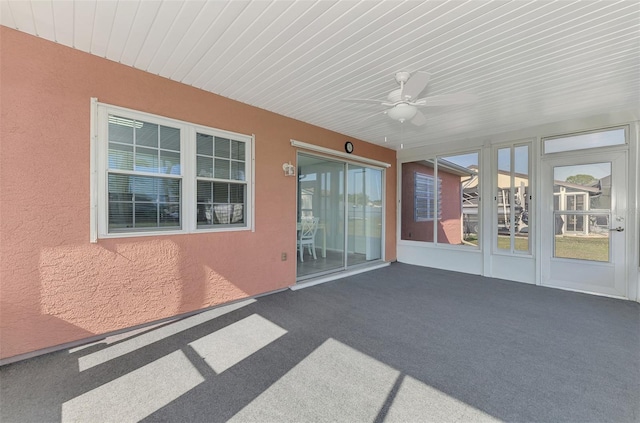 unfurnished sunroom featuring ceiling fan