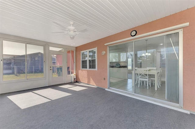 unfurnished sunroom featuring ceiling fan