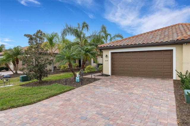 view of front of property featuring central air condition unit, a front yard, and a garage