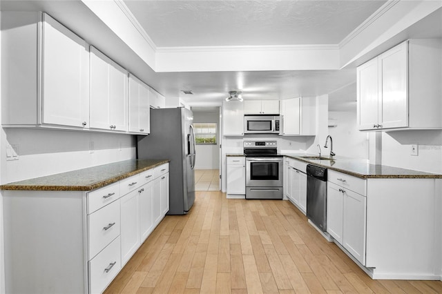 kitchen with sink, white cabinets, dark stone counters, and appliances with stainless steel finishes