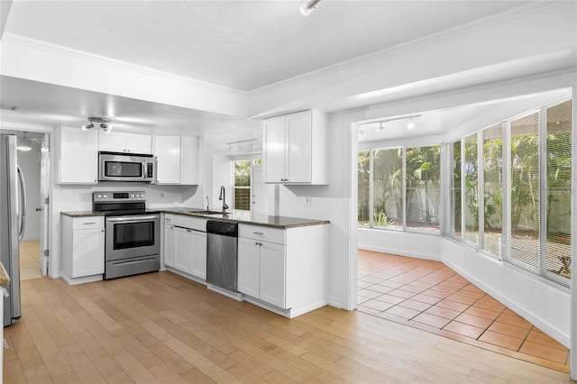 kitchen featuring white cabinets, sink, crown molding, light hardwood / wood-style flooring, and appliances with stainless steel finishes