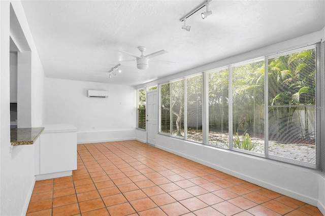unfurnished sunroom with an AC wall unit, ceiling fan, and rail lighting
