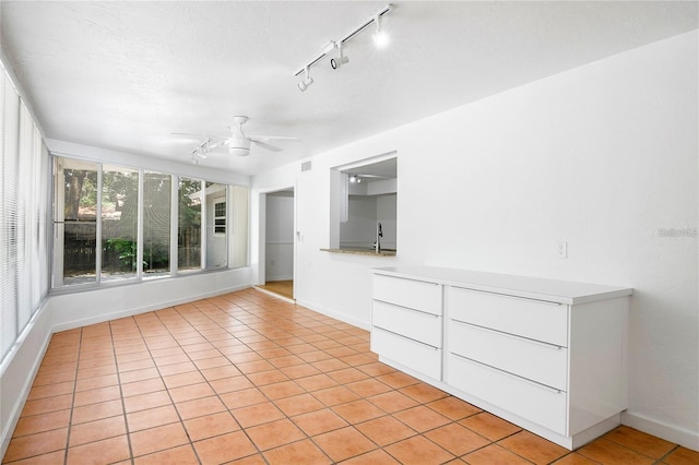 spare room featuring ceiling fan, sink, and light tile patterned floors