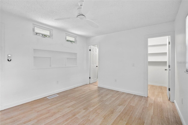 unfurnished room featuring a textured ceiling, light hardwood / wood-style floors, and ceiling fan