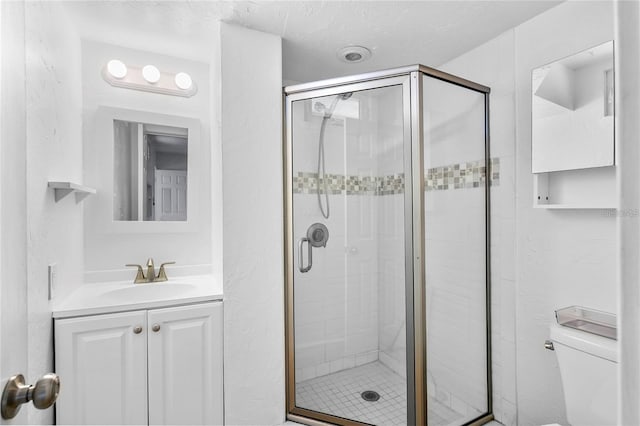 bathroom with a shower with door, vanity, and toilet
