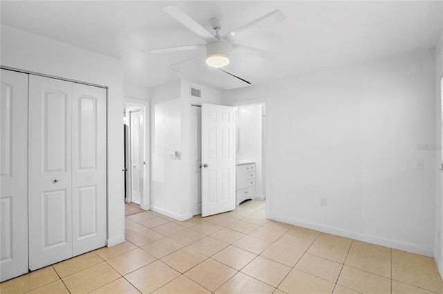 unfurnished bedroom with ceiling fan, a closet, and light tile patterned floors