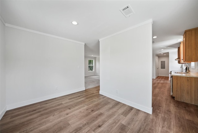 interior space with wood-type flooring, sink, and ornamental molding