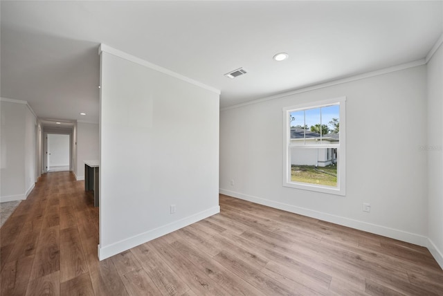 unfurnished room with light wood-type flooring and crown molding