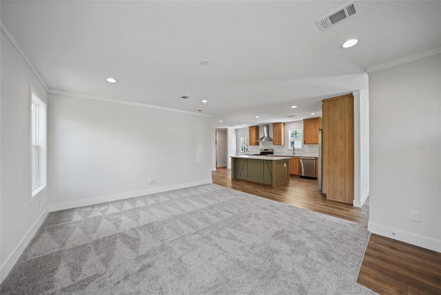 unfurnished living room featuring sink, light wood-type flooring, and crown molding