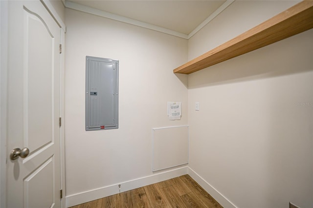 clothes washing area featuring hardwood / wood-style floors, ornamental molding, and electric panel