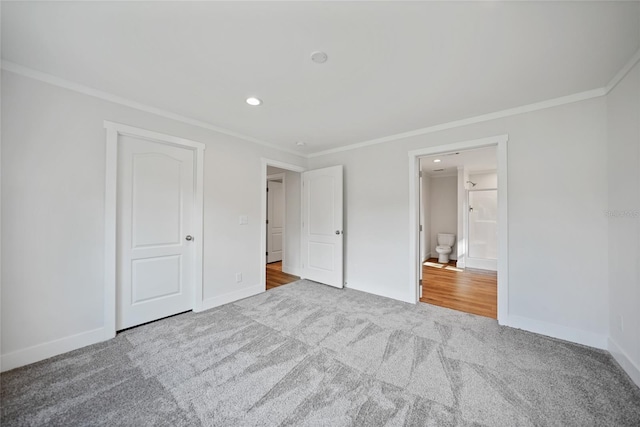 unfurnished bedroom featuring ensuite bathroom, crown molding, and carpet floors