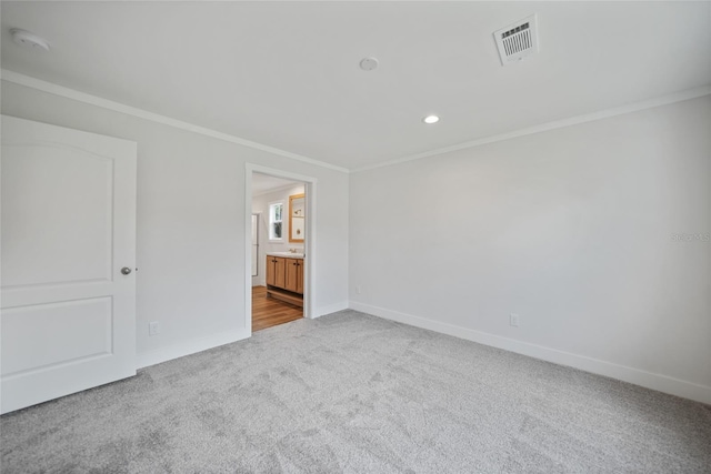 carpeted empty room featuring crown molding