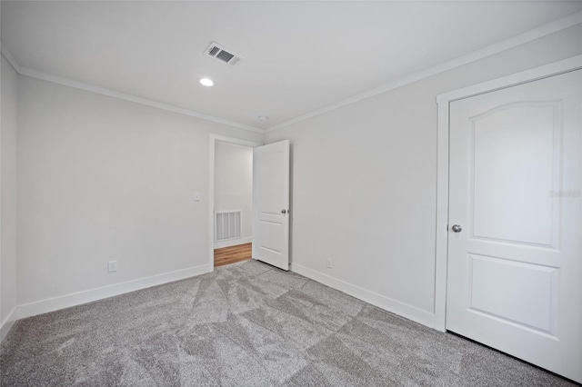 unfurnished bedroom featuring light carpet and crown molding