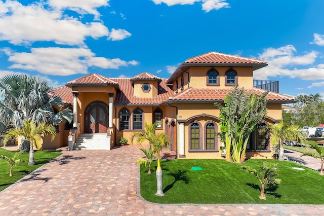 mediterranean / spanish house featuring a front lawn and french doors