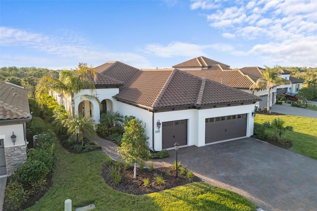 mediterranean / spanish home featuring a front yard and a garage