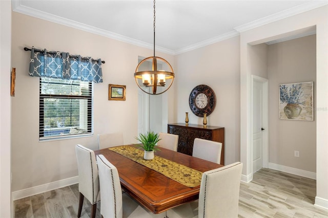 dining room with light wood-type flooring, crown molding, and an inviting chandelier