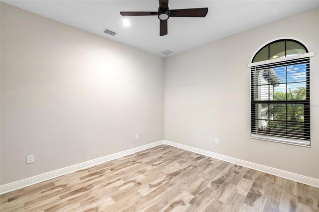 empty room with ceiling fan and light hardwood / wood-style floors