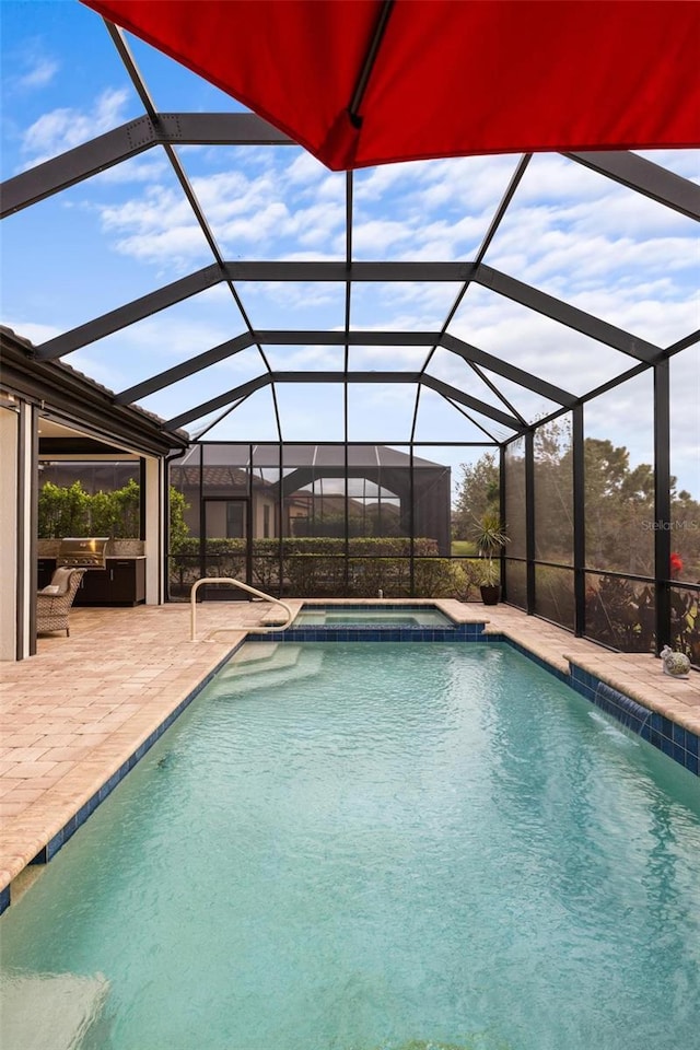 view of pool featuring a lanai, exterior kitchen, a patio, and an in ground hot tub