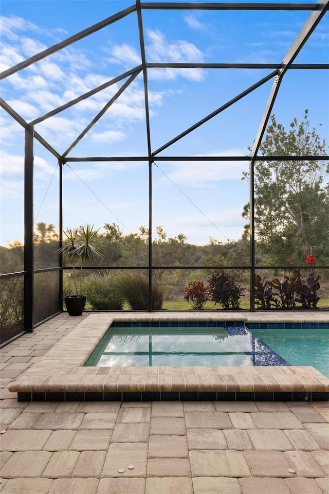 view of swimming pool with an in ground hot tub and a lanai